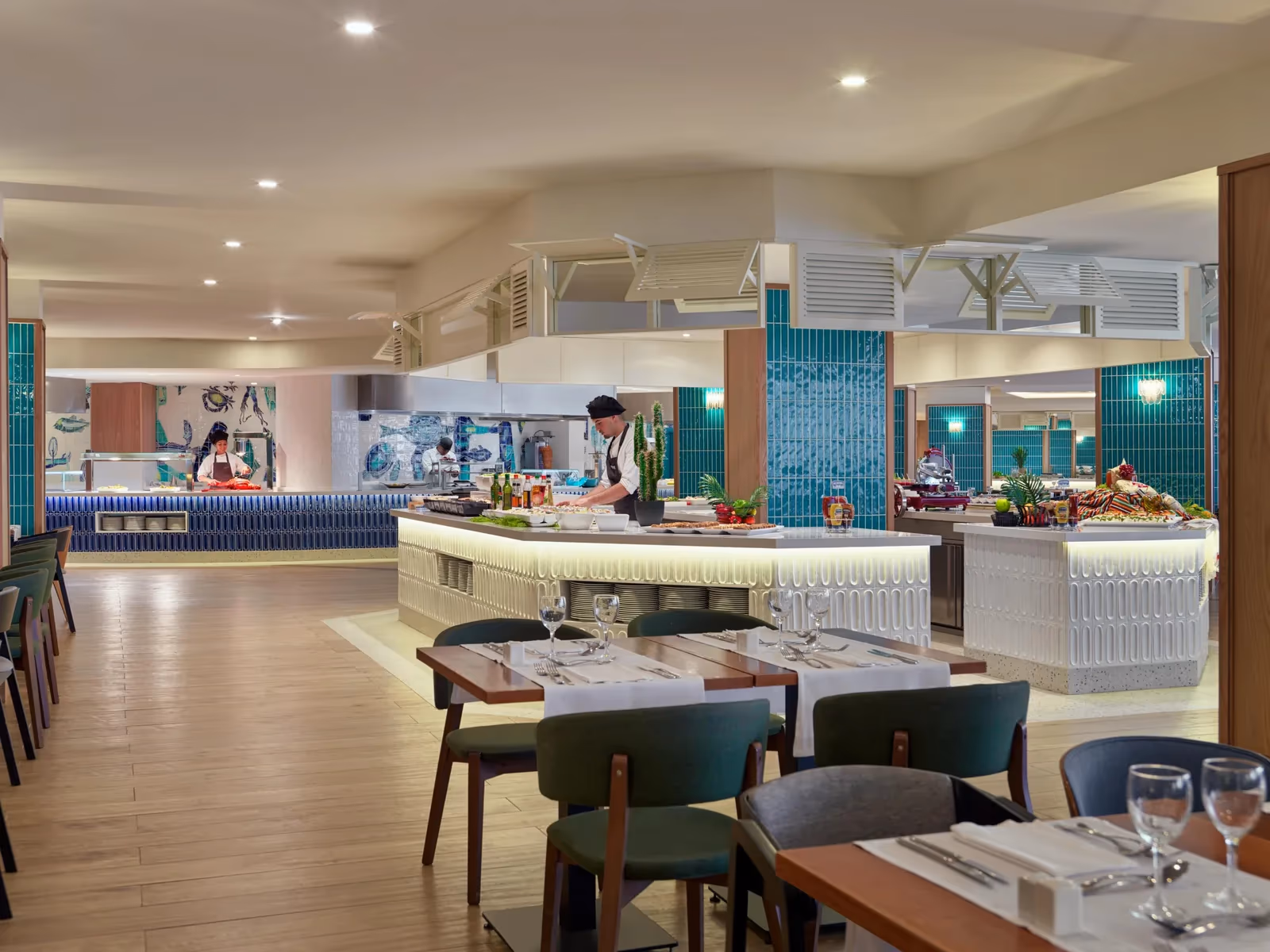 Buffetrestaurant met open keukens, gedekte tafels en groene tegelzuilen bij H10 Conquistador in Playa de las Américas