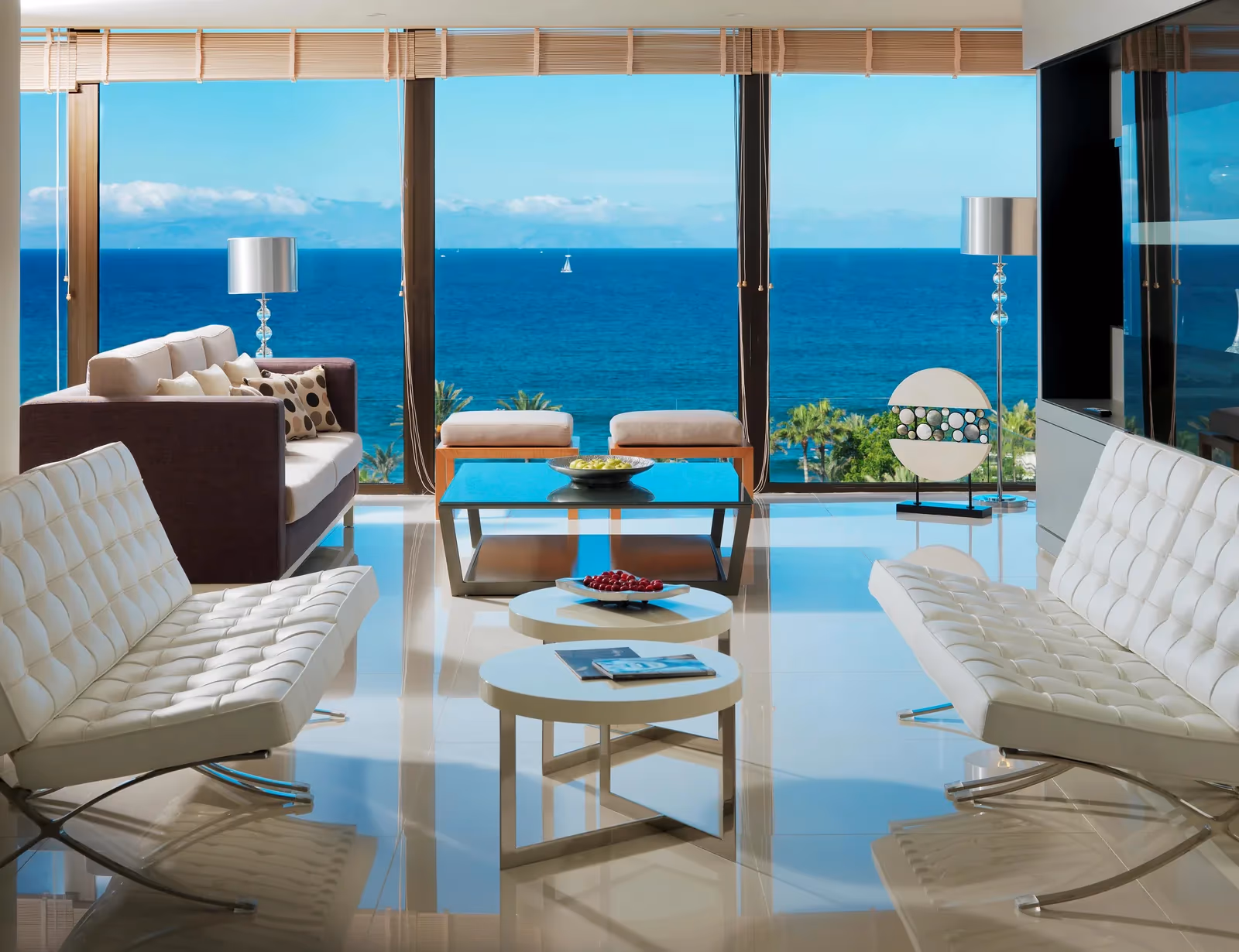 Lounge met witte designbanken en ramen tot de vloer met uitzicht op zee bij H10 Conquistador in Playa de las Américas