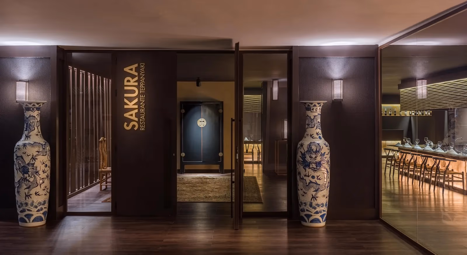 Ingang van restaurant Sakura met een naambord en twee grote blauw-witte vazen bij H10 Conquistador in Playa de las Américas