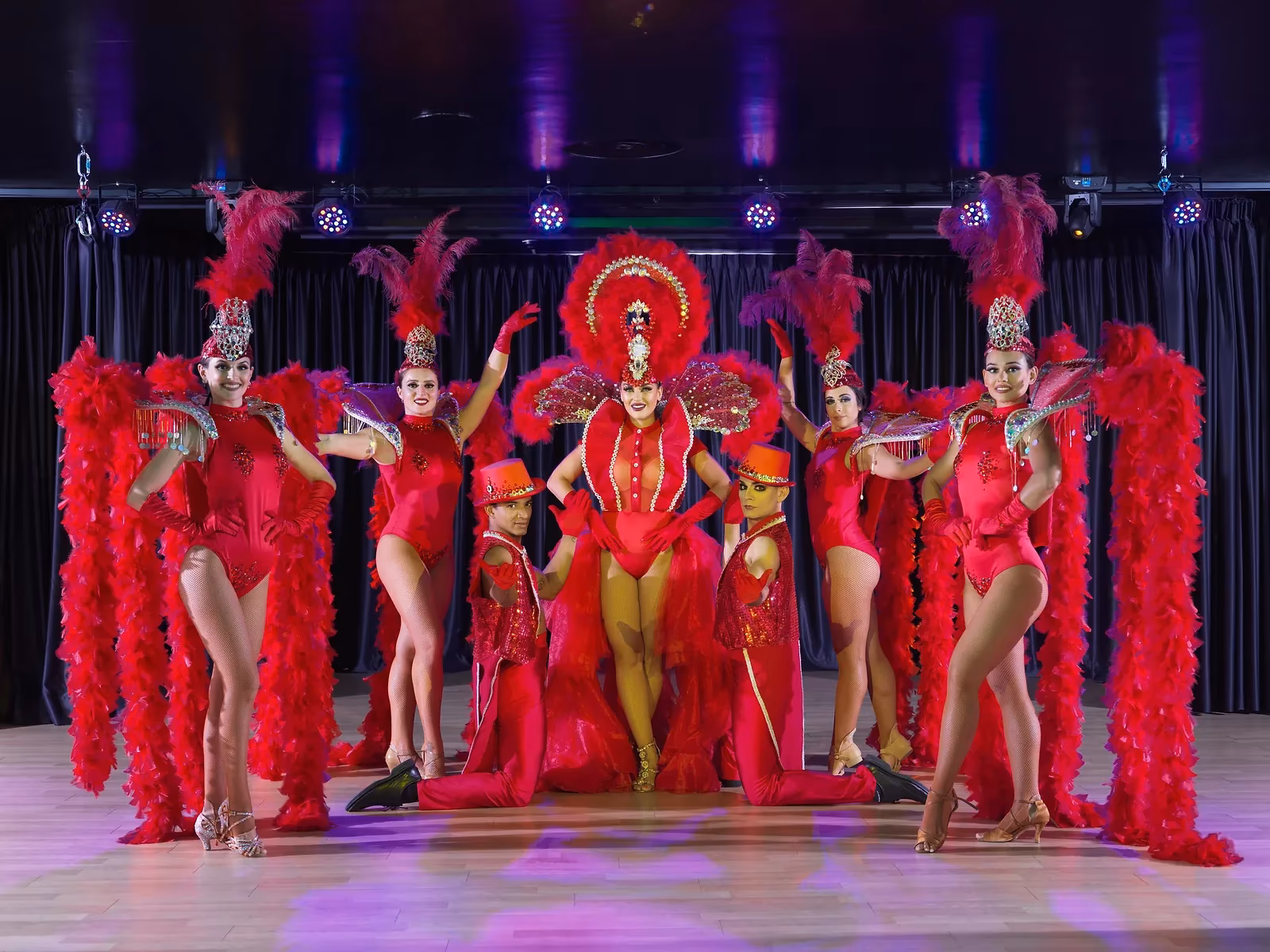 Dansers in rode kostuums met veren tijdens een show bij H10 Conquistador in Playa de las Américas