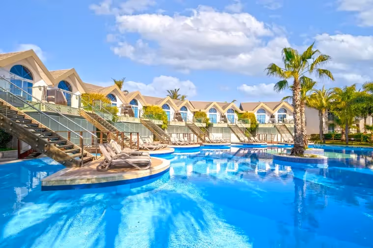 Palmen, villa's en een bad bij Long Beach Resort in Türkler