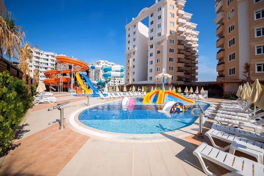 Hoge hotelblokken van Ramada Resort Lara met een glijbaanbad op de voorgrond